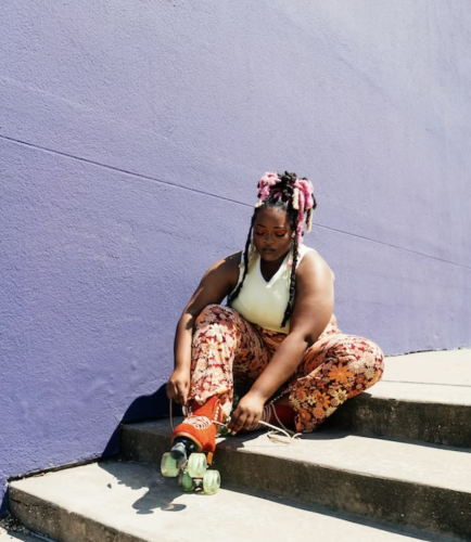 Larger-bodied Black woman tying up roller skates